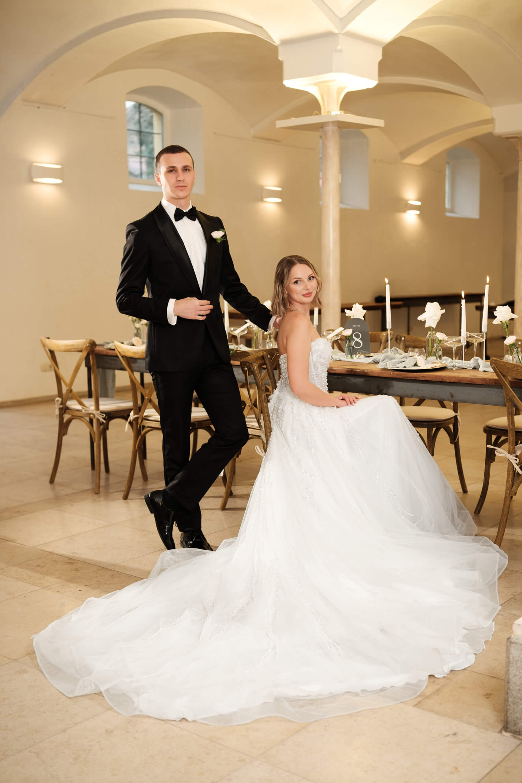 Braut und Bräutigam an der festlich gedeckten Hochzeitstafel